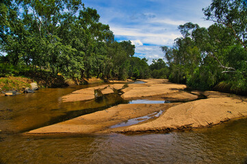 Tree lined river with sand bars and clear water in the Western Australian outback, in the North between Halls Creek and Wyndham
