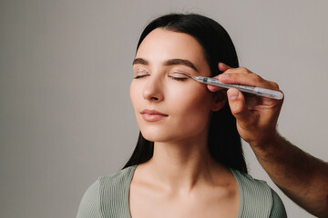 Upper Blepharoplasty. Surgeon is drawing marking lines on eyelid of patient to have accurate...