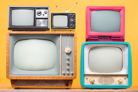 Retro TVs set front yellow background. Vintage old style filtered photo