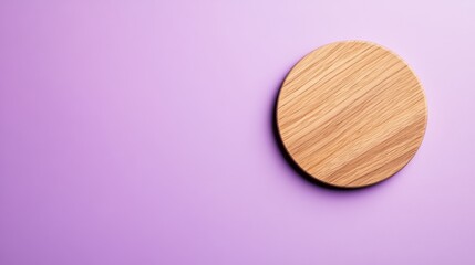 A light oak round wooden coaster is placed on a soft lavender background, highlighting its natural wood grain. The clean surface provides ample space for text or design