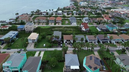 Gulf Coast beach houses on stilts to avoid flood, upscale villa mansion houses with private wooden jetty boat ramp pier, Laguna Bay South Padre Island, residential area, vacation rental, flyover