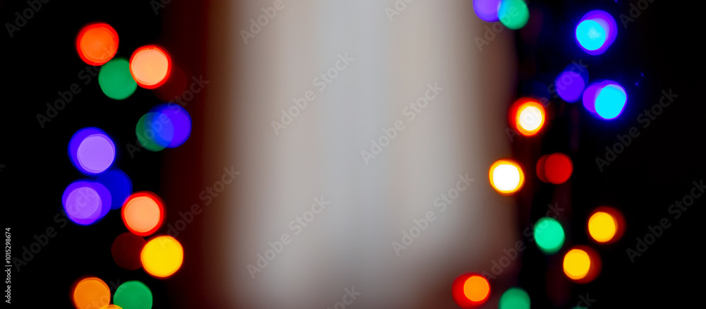 Wall mural bright bokeh on a black background with a light insert in the middle