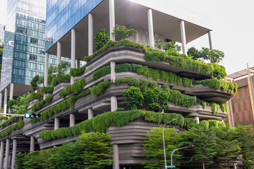 Modern, eco-friendly building with extensive green walls and rooftop gardens in Singapore. Facade...