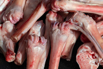 A pile of raw goat bones and cartilage, showcasing their fresh and natural state. Ideal for visuals related to culinary preparation, butchery, or food industry themes.