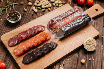Sliced gourmet smoked salami on a wooden board with herbs, perfect for charcuterie boards and snacks