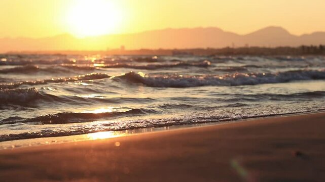 Sunset at sea. Balearic Sea, Salou, Spain. Beach, sea, small waves. Evening landscape on the coast. Vacation at sea