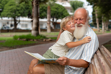 Heartwarming Embrace Between Grandfather and Grandson on a Park Bench