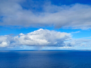 Obraz premium White clouds in summer sky over the ocean background