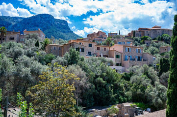 Deia, Mallorca cityscape with Serra de Tramuntana mountain landscape in the background, buildings on a hill, majorca spain