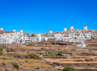 The skyline of Chora in Amorgos, located in the center of the island, overlooking the Aegean Sea. Whitewashed houses and windmills on top of the mountain. Amorgos Island, Cyclades, Greece.