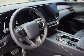 Closeup of a modern car steering wheel with control buttons for technology and convenience