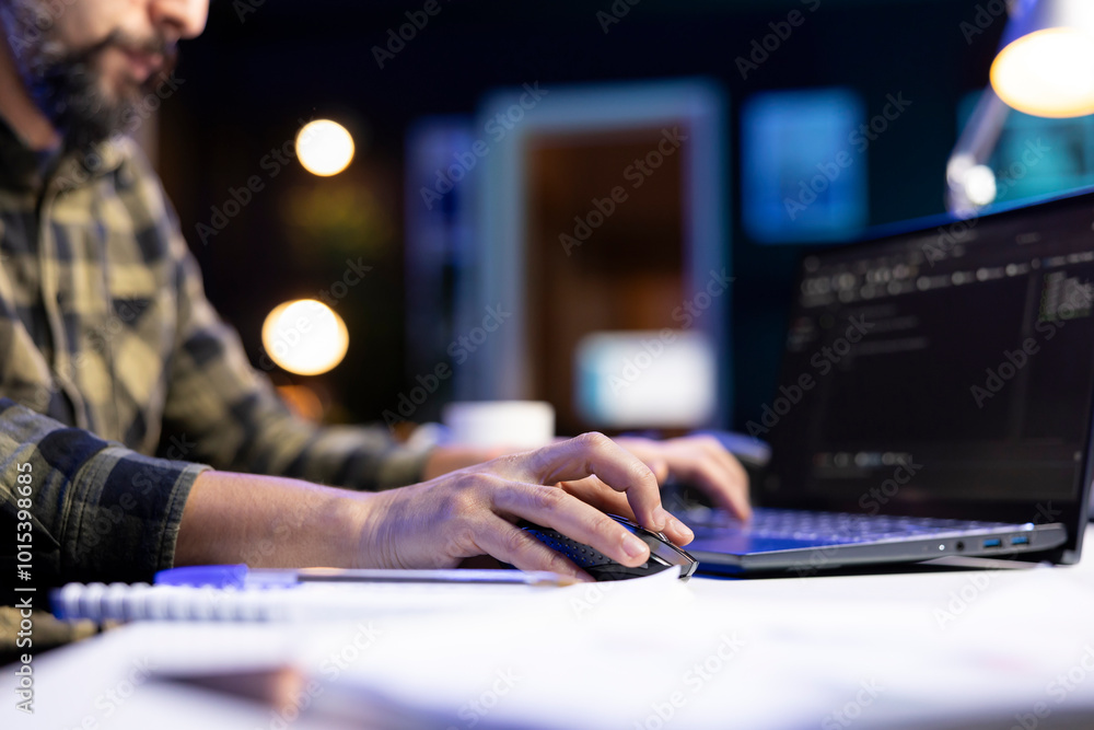 Poster closeup of male individual typing on a laptop and using a mouse to manage software codes and systems