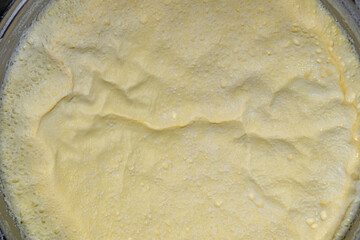 A layer of cream formed on milk boiled in a saucepan. Close-up.