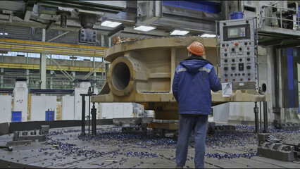 Worker with remote control and rotating lathe. Stock clip. Worker with control panel for factory...