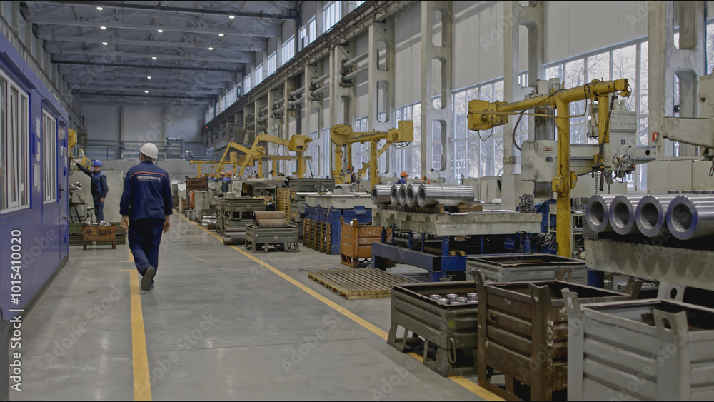 Poster worker with helmet at factory with metalworking machines. stock clip. specialty of working at factor