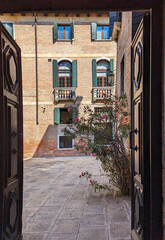 Fototapeta premium The door opens to the traditional roman architecture, Venice, Italy