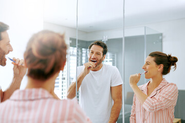 Brushing teeth, cleaning and mirror with couple in bathroom for oral hygiene, morning and dental. Self care, wellness and toothbrush with man and woman at home for gum treatment, toothpaste or health