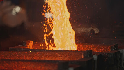Pit pours liquid metal into molds. Stock footage. Liquid mass of molten metal pours out of pit....