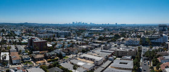 Aerial perspective of Los Angeles with downtown skyline, dense urban landscape, clear blue sky, and...