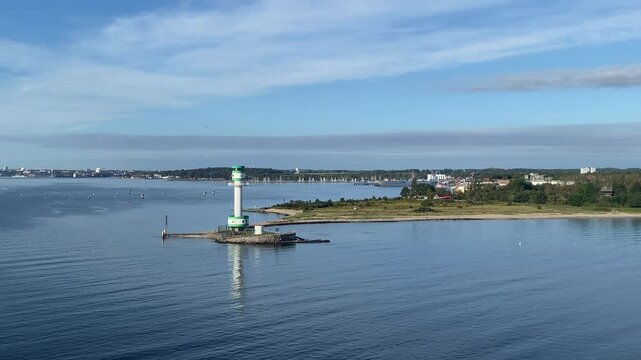 A lighthouse stands on a small island in a quiet coastal landscape under a blue sky, Friedrichsort, Kiel, Schleswig-Holstein, Germany, Europe