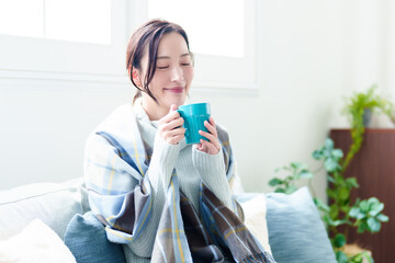 リビングで飲み物を飲む女性