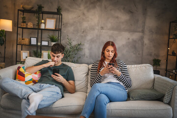 Obraz premium Young couple sit and use cellphone, realistic photo of phone addiction