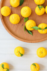 白い背景に、たくさんの柚子の実が転がっている。俯瞰で見た写真。