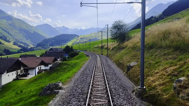 Front View From Glacier Express on Railroad Tracks and Mountainscape and Valley in a Sunny Summer Day in Sedrun, Surselva, Oberalp, Grisons, Switzerland, Europe