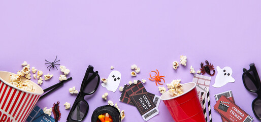 Composition with tasty popcorn, cinema tickets and Halloween decorations on lilac background