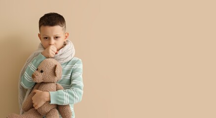 Ill little boy with toy bear coughing on beige background
