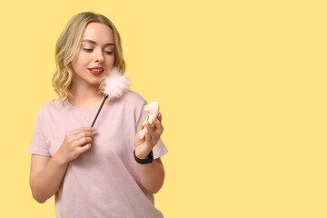 Beautiful young woman with different sex toys on yellow background