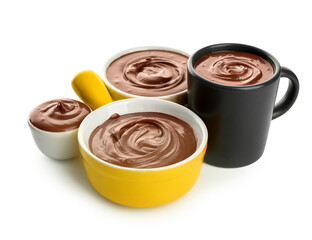 Bowls and cup of tasty melted chocolate on white background