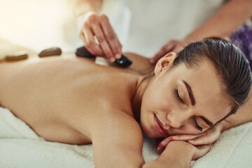 Hot stone therapy, massage and woman rest in luxury, spa or resort for wellness or healing treatment. Natural detox, comfort and heat rock care with zen, relax and holiday break for cosmetic health