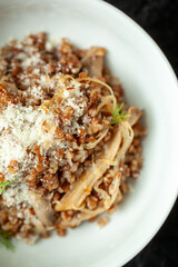 Buckwheat porridge with oyster mushrooms and parmesan cheese served on a white plate, a healthy and delicious vegetarian meal perfect for lunch or dinner