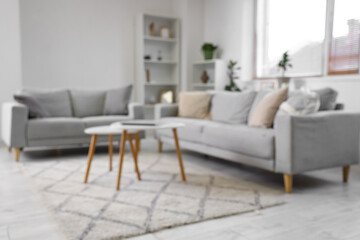 Stylish interior of living room with sofa and coffee table, blurred view