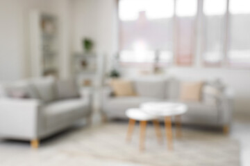 Stylish interior of living room with sofa and coffee table, blurred view