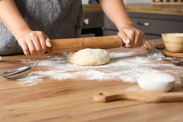 Woman preparing traditional cinnamon rolls in kitchen