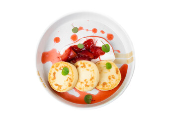 Syrniki or cheese pancakes with cream sauce and strawberry jam in white plate on white background
