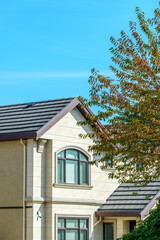 A perfect neighborhood. Houses in suburb at Fall in the north America. Top of a luxury house with nice window over blue sky.