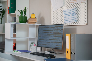 Programmer's desk with computer monitor and folders in office