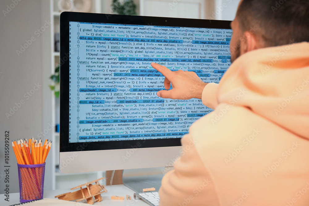 Poster male programmer working with computer at desk in office, closeup