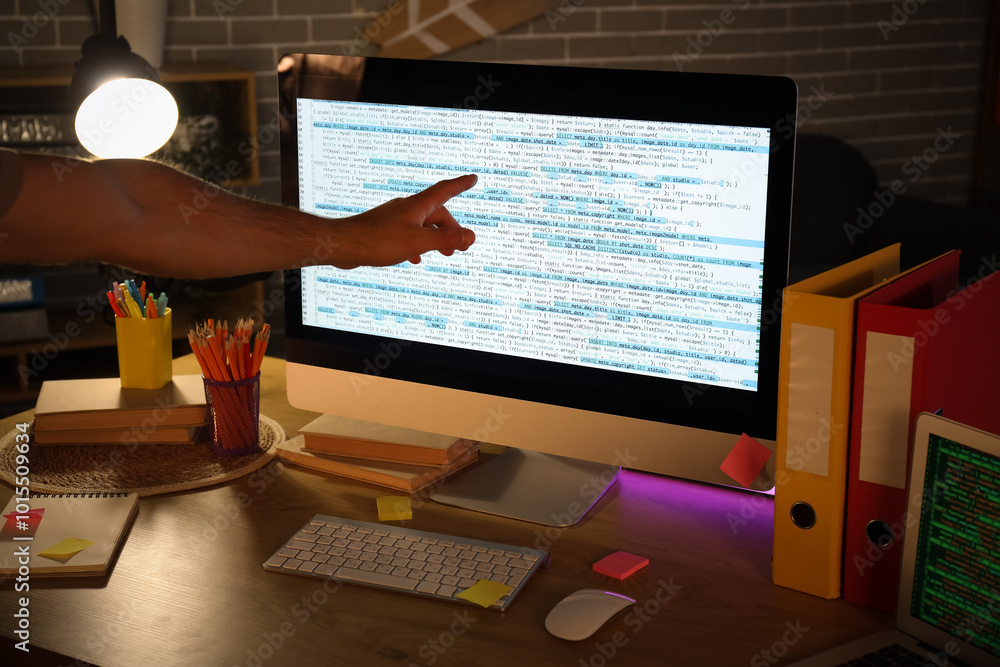 Aufkleber male programmer working with computer on desk in dark office