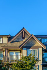 A perfect neighborhood. Houses in suburb at Fall in the north America. Top of a luxury house with nice window over blue sky.