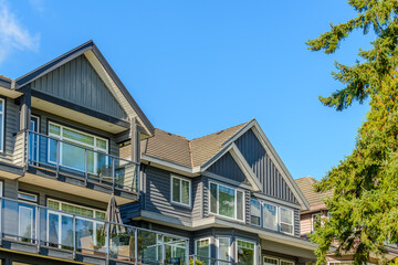 A perfect neighborhood. Houses in suburb at Fall in the north America. Top of a luxury house with nice window over blue sky.