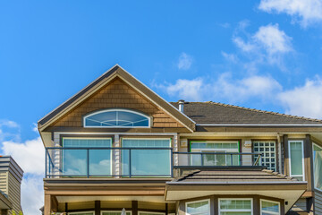 A perfect neighborhood. Houses in suburb at Fall in the north America. Top of a luxury house with nice window over blue sky.