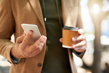 Businessman, hands and smartphone with coffee in city for travel app, information and update of location. Person, outdoor and drink with tech in morning for ride share, notification and booking trip
