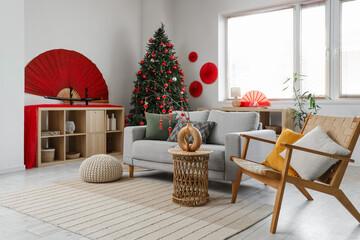 Interior of living room decorated for Japanese New Year celebration with sofa, armchair and fir tree