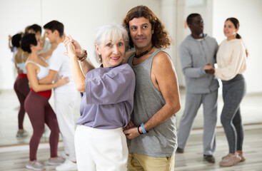 Caucasian man and mature woman learning paired latin dances