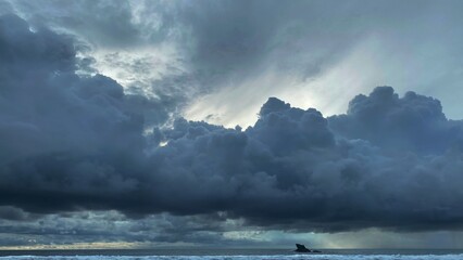 A dramatic stormy sky with dark clouds over a choppy sea.