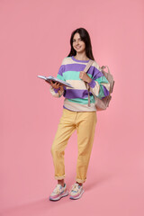 Cute teenage girl with backpack and book on pink background © New Africa